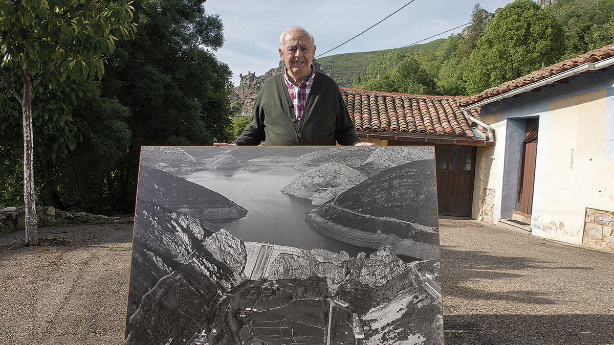 Eutiquiano Familiar con una vieja foto del pantano de Luna que conserva en su casa y explica metro a metro. "Ahí se ven los barracones". | MAURICIO PEÑA