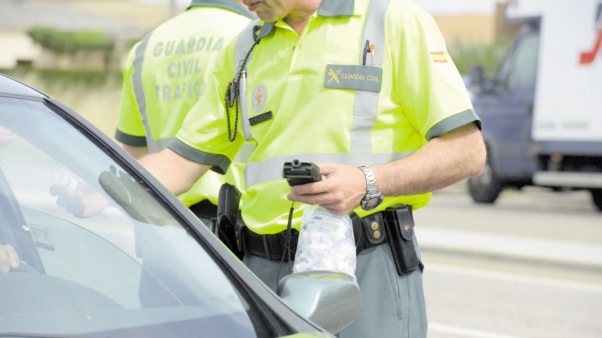 Dos agentes de la Guardia Civil de Tráfico llevan a cabo un control de alcoholemia en una de las carreteras de la provincia de León.| MAURICIO PEÑA