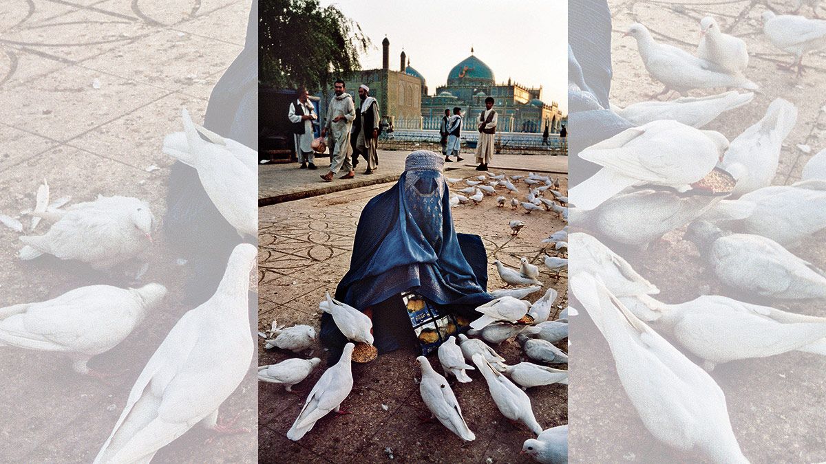 27/09/2008. Una mujer afgana alimenta a las palomas en un parque al lado de la mezquita Hazrat Ali, en la ciudad santa de Mazar-E-Sharif.