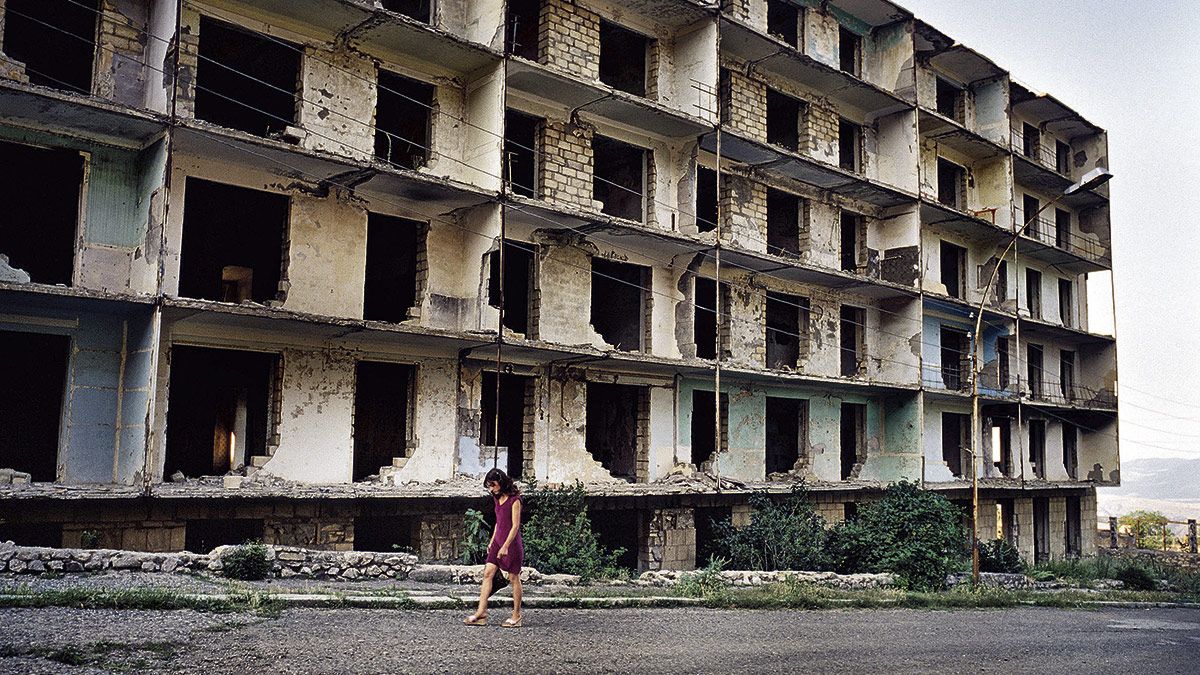 13/07/2007. Una mujer armenia pasa al lado de un bloque de apartamentos destruido en la calle Baranda, una de las más importantes de la ciudad de Shushi.