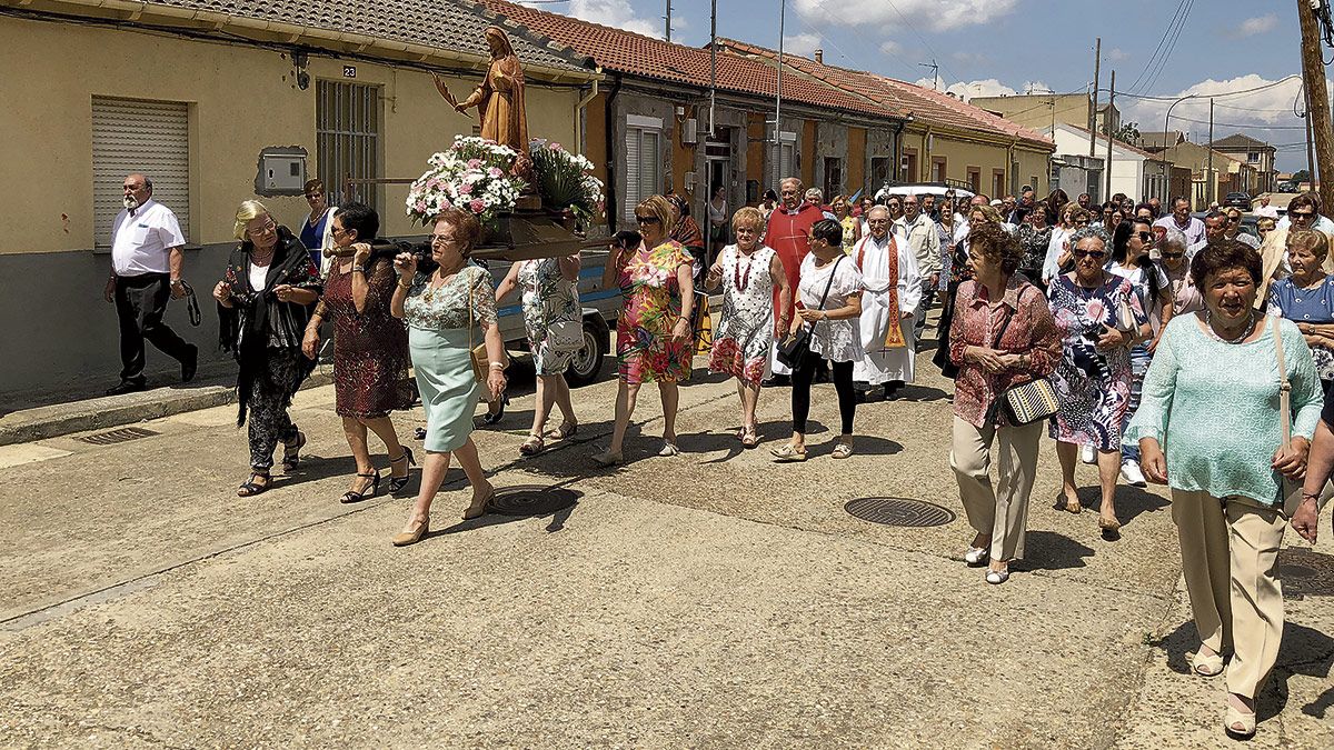 La procesión con la talla de Santa Marina recorrió algunas calles del barrio bañezano del Polvorín. | ABAJO