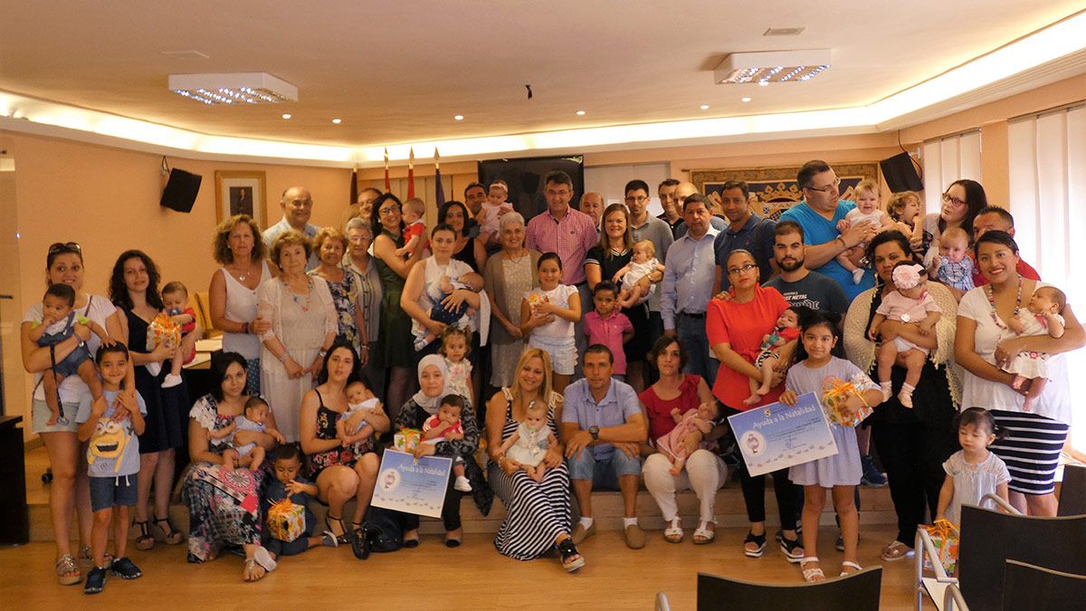 Las familias coyantinas que este lunes recibieron el ‘cheque bebé’ en Valencia de Don Juan junto a buena parte de la corporación municipal. | L.N.C.