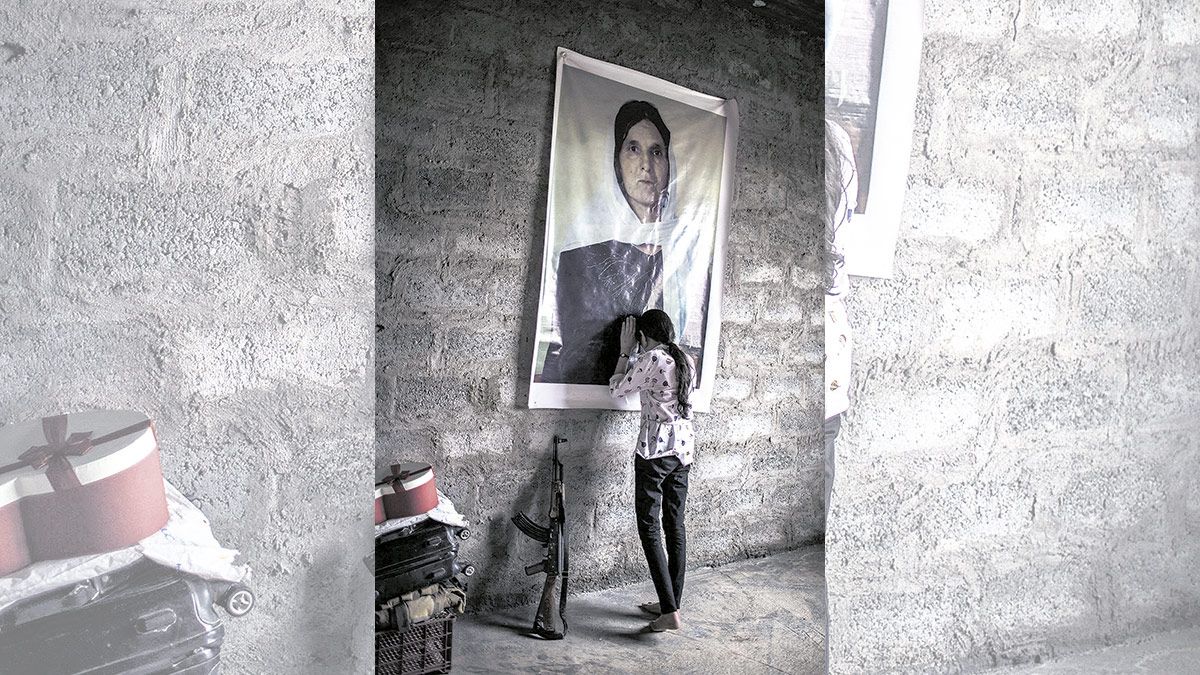 07/05/2018. Sharihan, de 19 años, llora apoyada sobre el retrato de su madre, asesinada por el Estado Islámico, en una habitación de su casa en Sinune. 07/05/2018. Sharihan, de 19 años, llora apoyada sobre el retrato de su madre, asesinada por el Estado Islámico, en una habitación de su casa en Sinune.