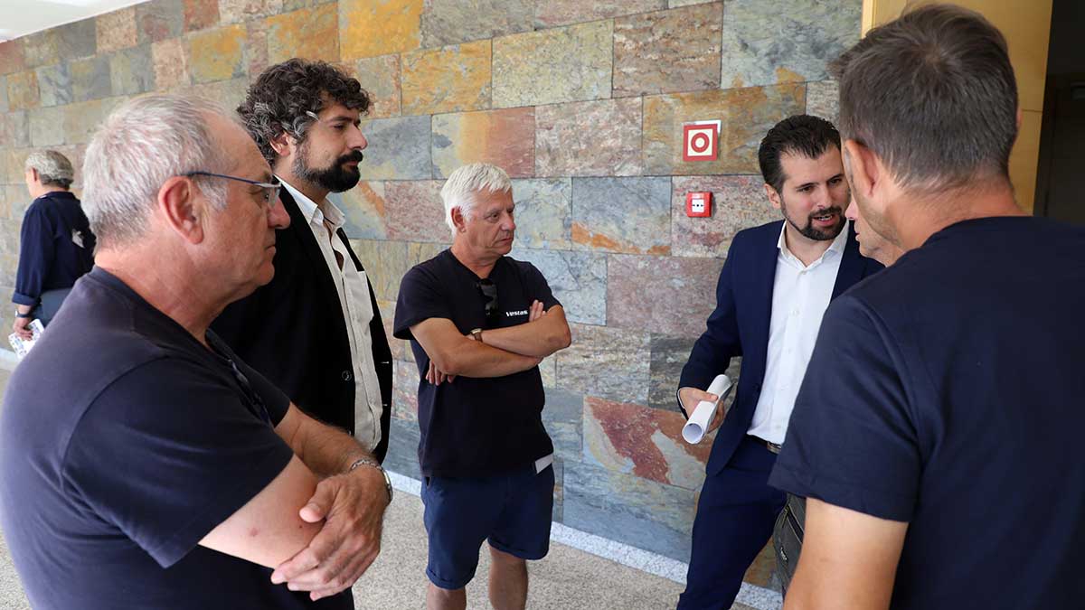 El procurador de IU, José Sarrión, y el portavoz socialista Luis Tudanca conversan con representantes y trabajadores de Vestas. | ICAL