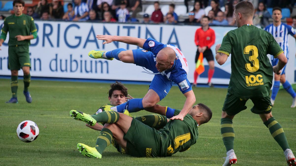 Isi es frenado por dos jugadores de Las Palmas Atlético. | FRANCISCO L. POZO