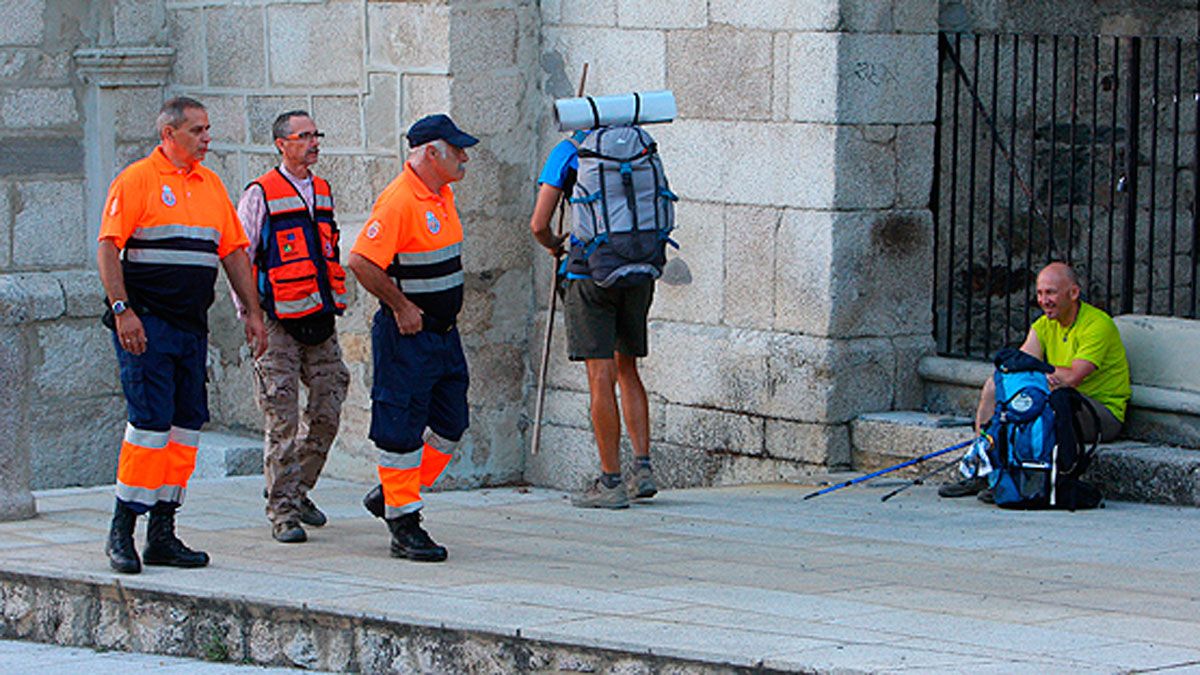 Voluntarios de Protección Civil, junto a unos peregrinos en Molinaseca. | C. C.