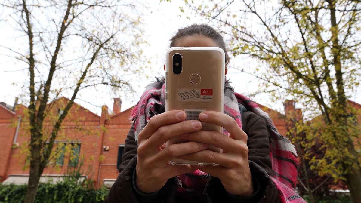 Una joven utiliza su teléfono móvil junta a un instituto de la capital vallisoletana. | ICAL