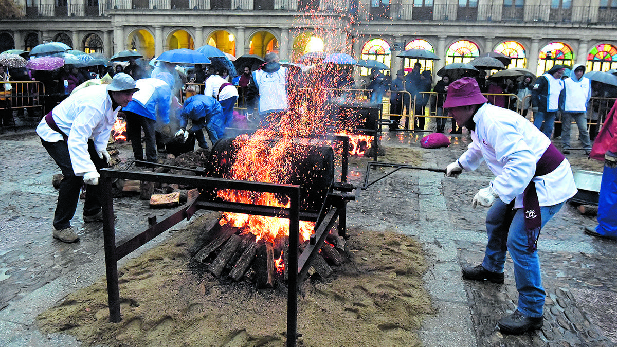La lluvia no ha impedido el reparto de más de 3.000 kilos de castañas en la plaza de San Marcelo. | SAÚL ARÉN