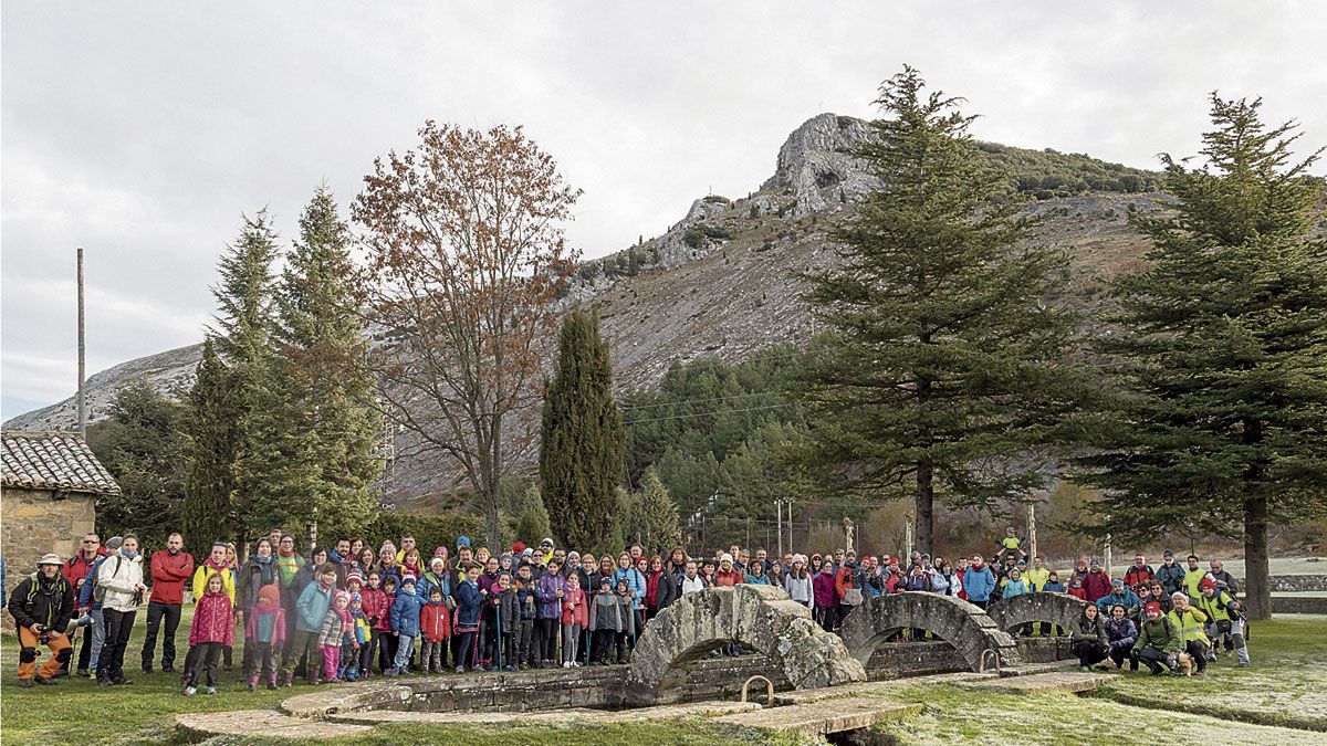 Foto de gran grupo en la fuente de la Reana con las cumbres que se subirán. | VICENTE GARCÍA