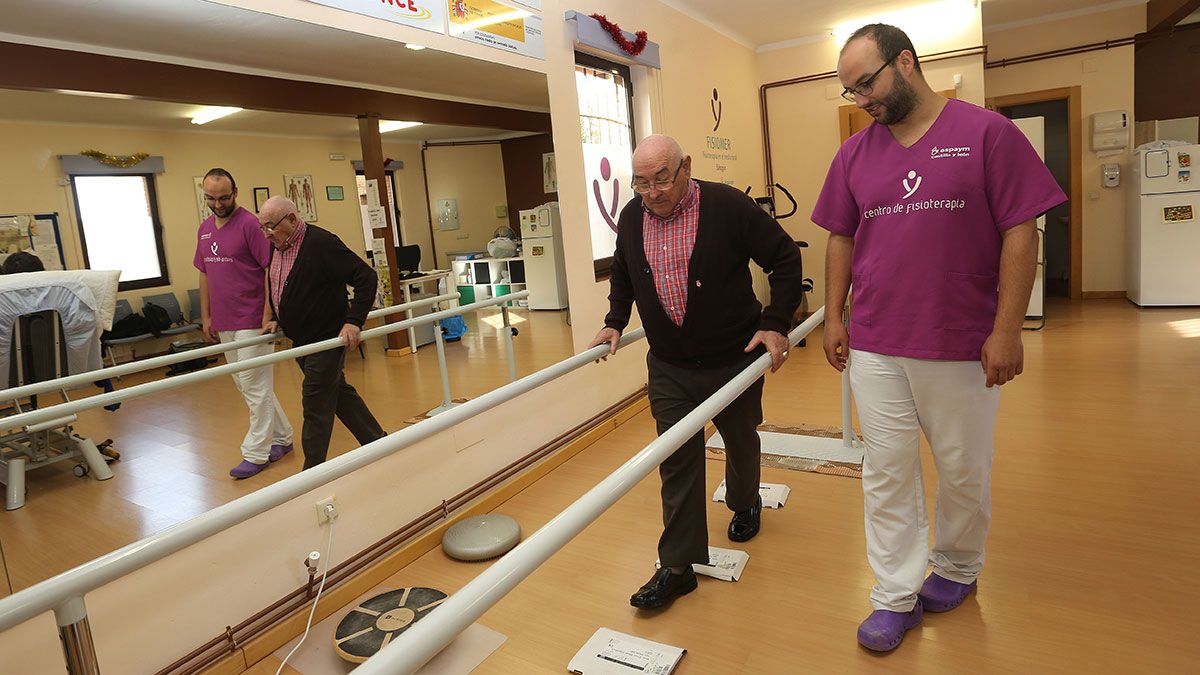 El fisioterapeuta Rodrigo Antón (D), con un usuario realiza ejercicios de rehabilitación en el centro de Sahagún. | ICAL