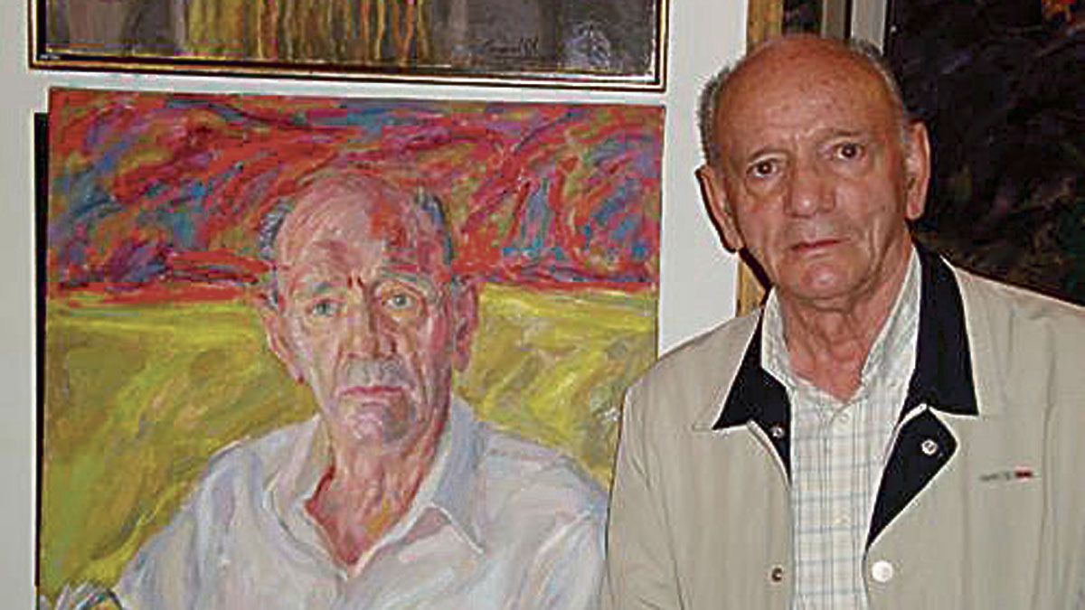 Gaspar Moisés Gómez posa con el retrato que le hizo Modesto Llamas.