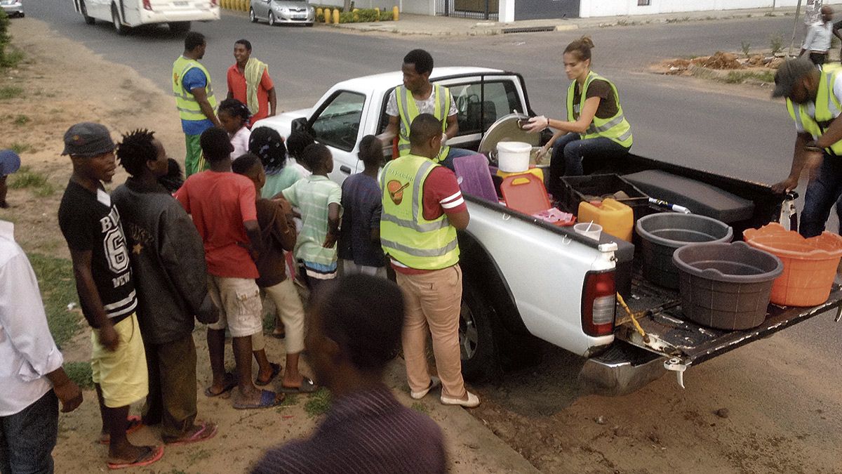 Los dos leoneses se muestran encantados con el trato recibido en Mozambique. A la derecha, repartiendo la sopa solidaria por las calles a los más necesitados.