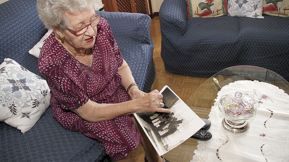 Irene, ahijada de Eleuterio Canseco, muestra una foto en la que aparece su padrino con otros amigos. | ICAL