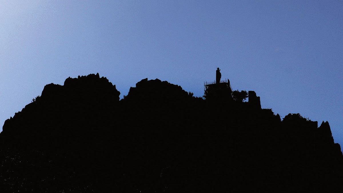 Contraluz en el que se puede ver la silueta del castillo y el Sagrado Corazón sobre las rocas. | MAURICIO PEÑA