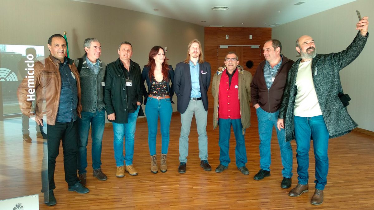 Representantes de los trabajadores con los líderes de Podemos que presentaron la resolución.