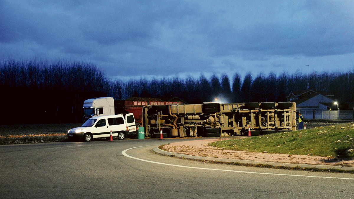 El vuelco del camión se produjo este lunes en la rotonda que une las carreteras CL-622 y LE-420 en Requejo. | ABAJO