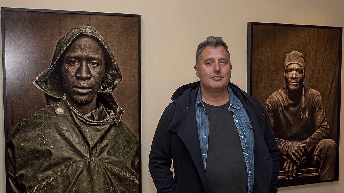 David Palacín posa entre dos de los retratos que se exponen desde el pasado jueves en el CLA. | VICENTE GARCÍA