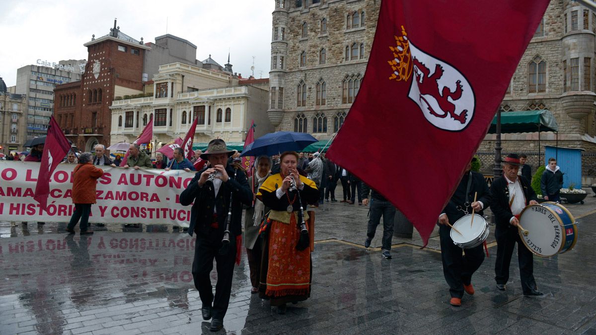 La lluvia hace acto de presencia en una manifestación a favor de la identidad de la región leonesa frente a Casa Botines. | MAURICIO PEÑA