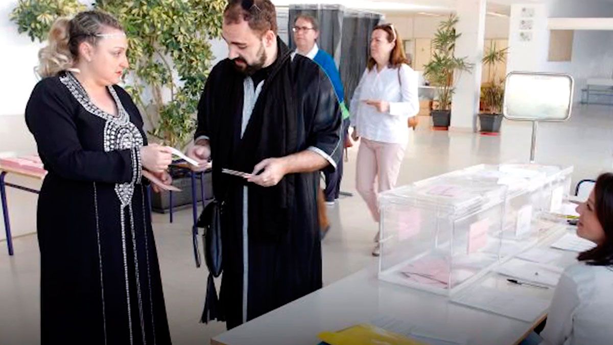 Dos personas acuden a votar haciendo un alto en las fiestas de 'Moros y Cristianos'. | ABC