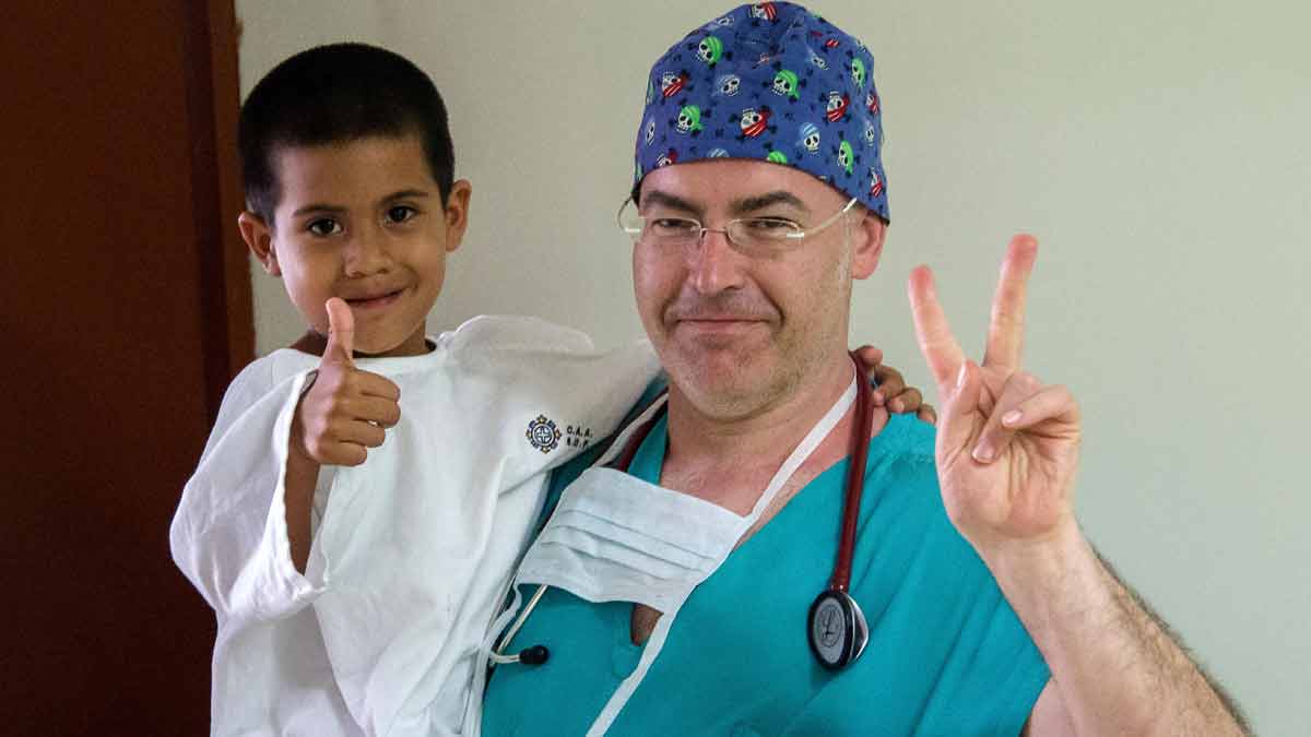 El anestesista leonés Juan Carlos Sánchez, con uno de los niños a los que atiende en Perú. | ICAL