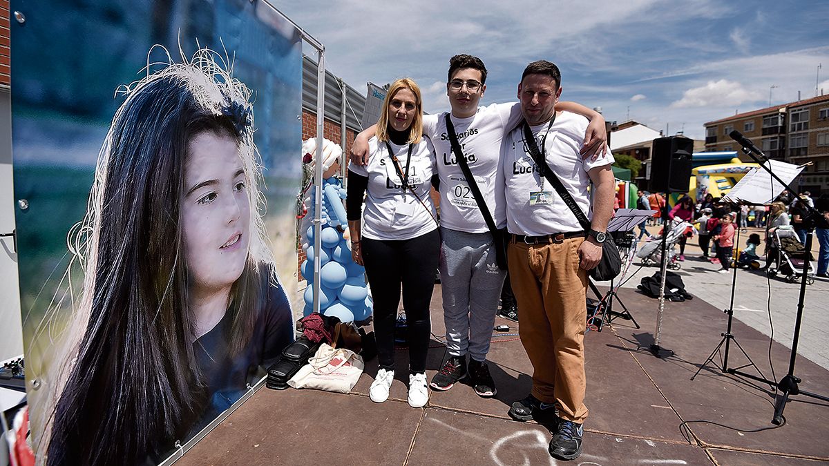 Los padres y el hermano de Lucía posan junto a una foto de la pequeña durante el acto organizado este sábado para combatir el cáncer infantil. | SAÚL ARÉN Los padres y el hermano de Lucía posan junto a una foto de la pequeña durante el acto organizado este sábado para combatir el cáncer infantil. | SAÚL ARÉN