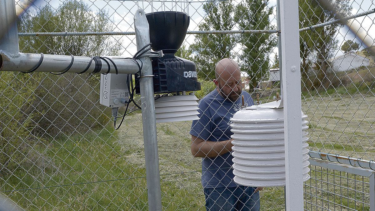 Miguel Ángel, un vecino de Villaceid, observa la moderna estación meteorológica que en su pueblo han instalado "los cazatormentas". | MAURICIO PEÑA