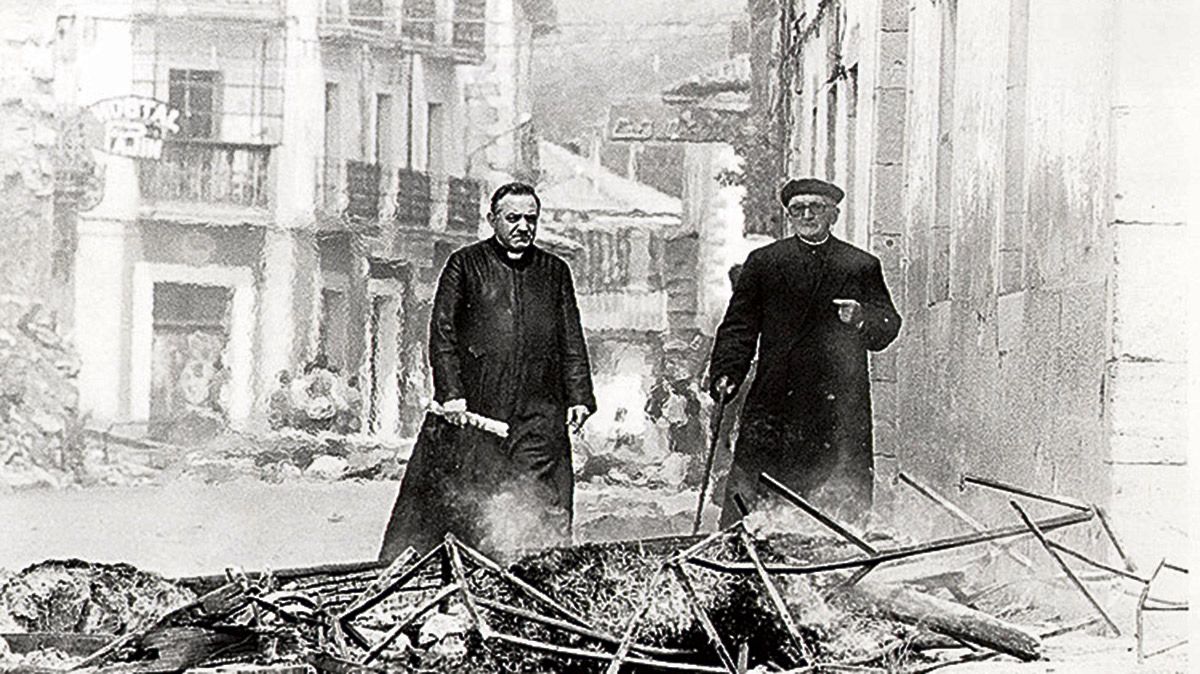Una de las imágenes más repetidas del conflicto de Riaño, don Antonio camina entre las ruinas acompañado de otro cura, don Eustaquio. | MAURICIO PEÑA