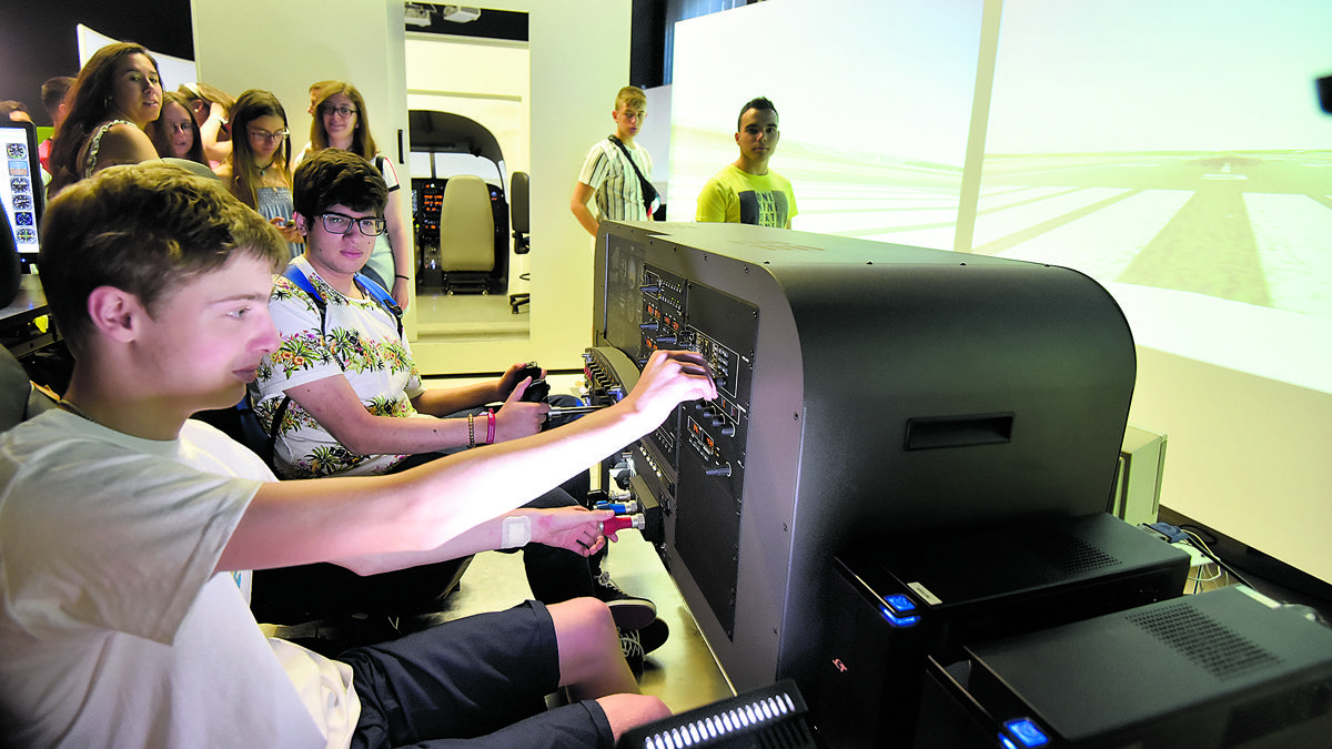 Jóvenes visitando el simulador de vuelo de la Universidad de León. | SAÚL ARÉN