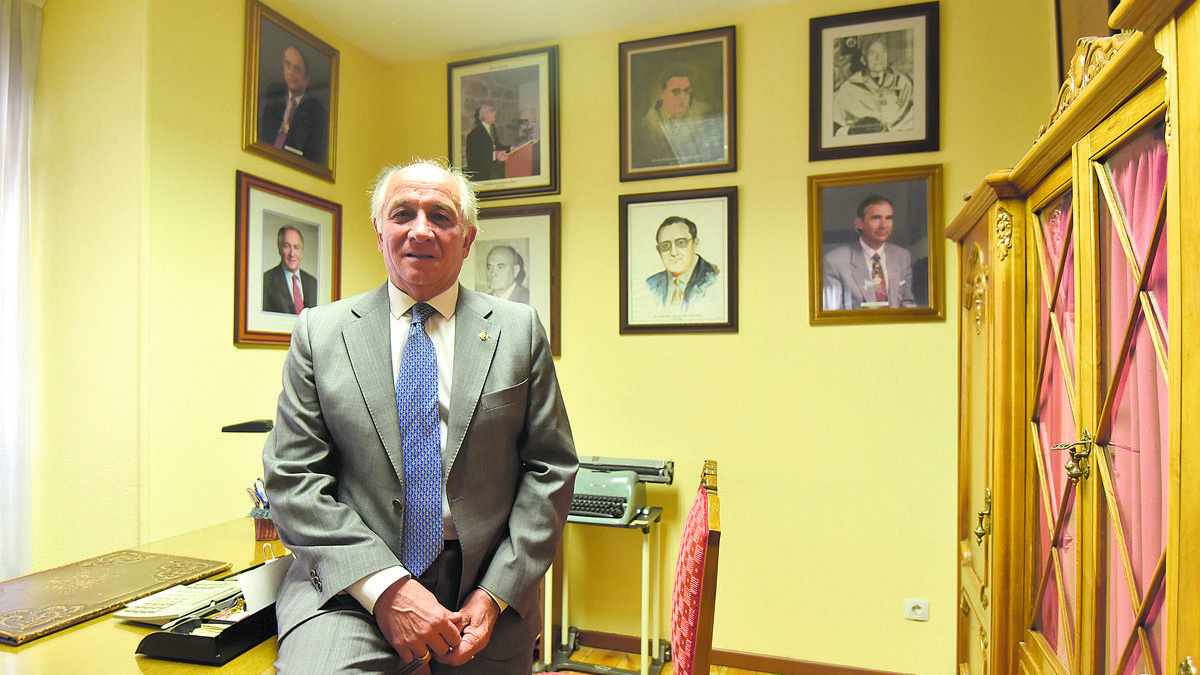 El decano del Colegio Oficial de Titulares Mercantiles de León, Antonio Jarrín, posa junto a los retratos de sus antecesores. | SAÚL ARÉN