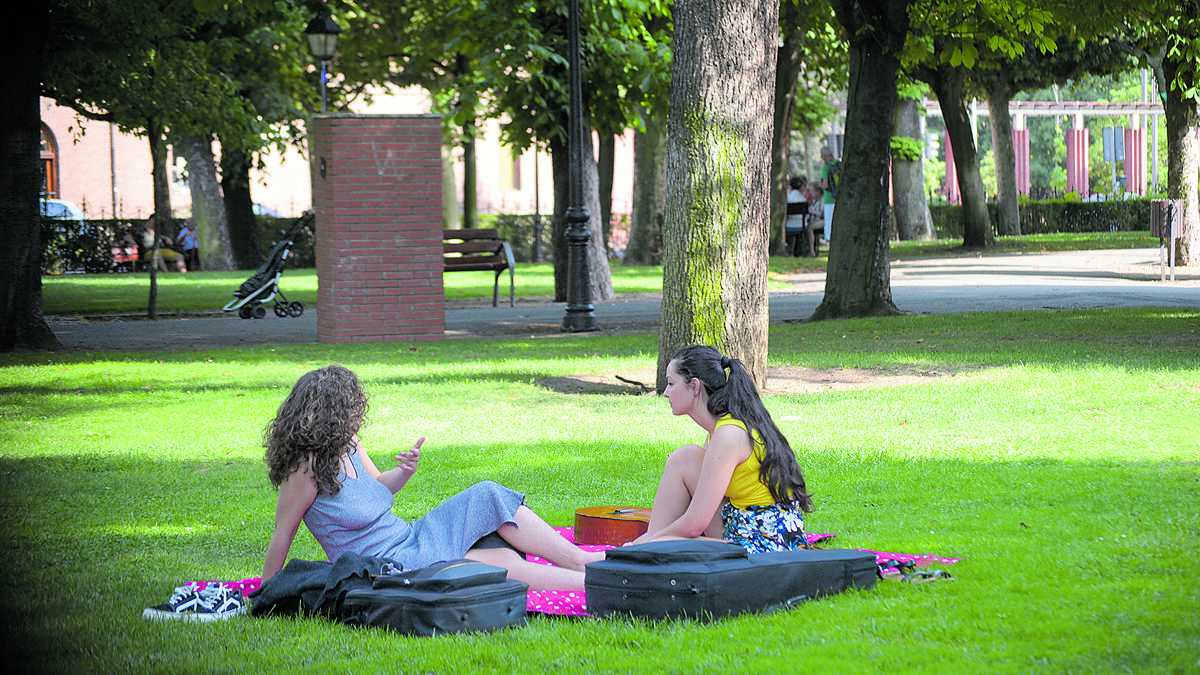 Jóvenes disfrutando de un tarde de verano a la sombra en el Jardín de San Francisco. | MAURICIO PEÑA