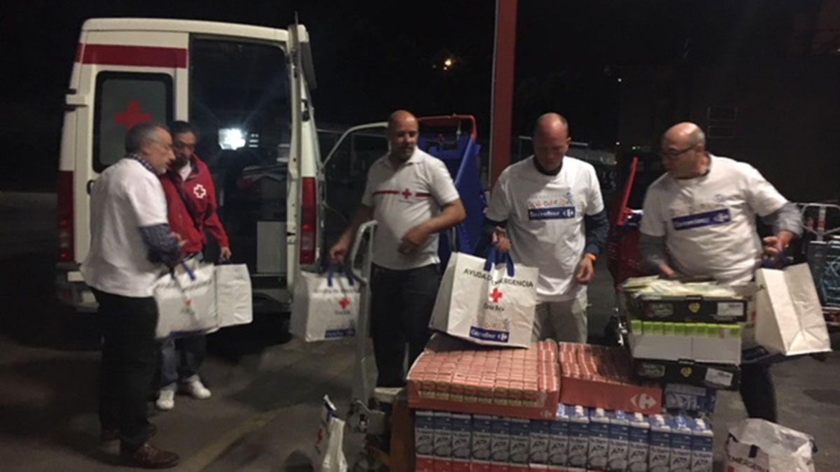Voluntarios de Cruz Roja cogiendo alimentos en Carrefour para los participantes de los campamentos. | L.N.C.