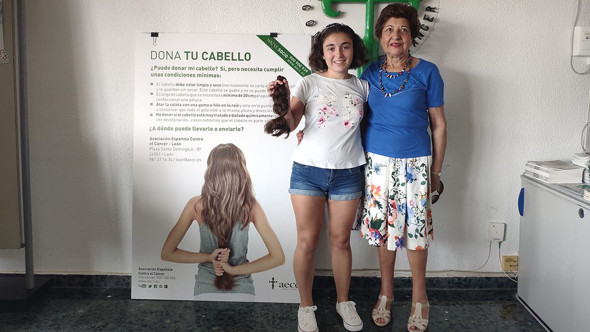 La donante Elena sujetando su trenza cortada junto a su abuela Vicenta. | N. CARPINTERO