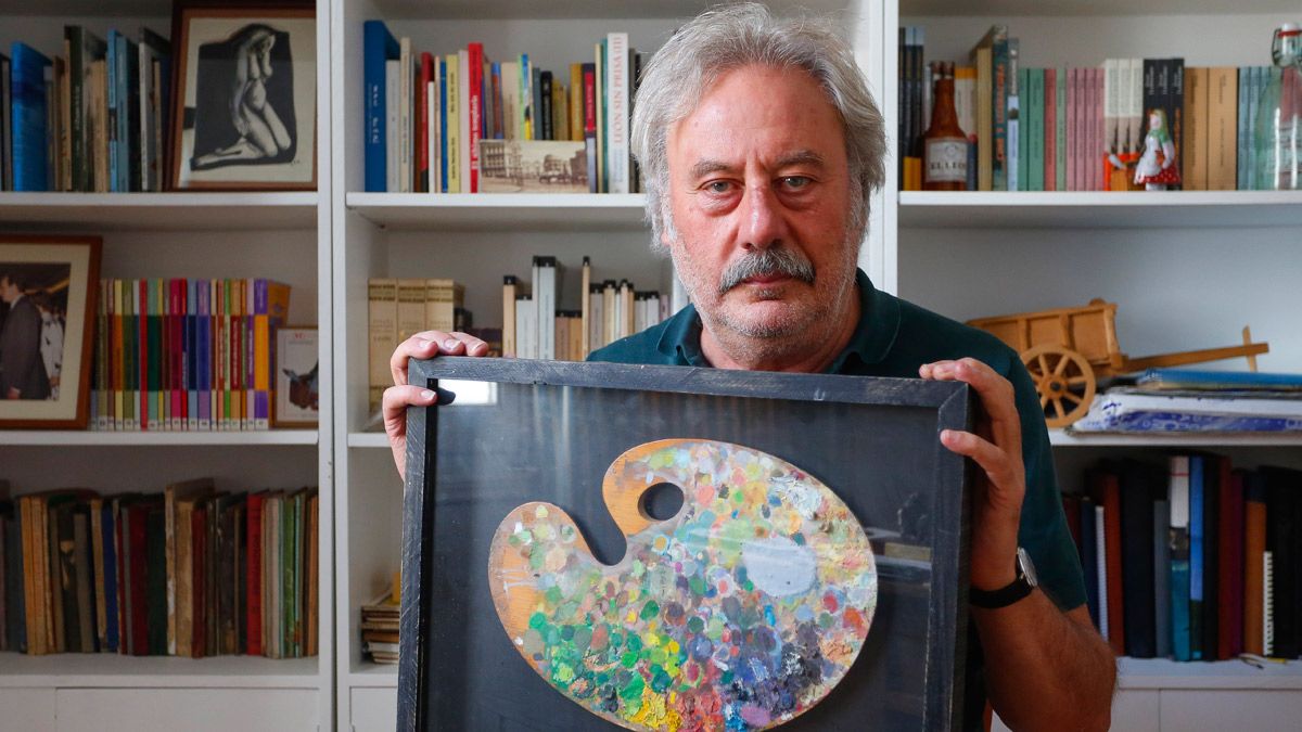 El escritor Julio Llamazares posa con la paleta del pintor fallecido Emiliano Ramos, que atesora en su casa. | Carlos S. Campillo / ICAL