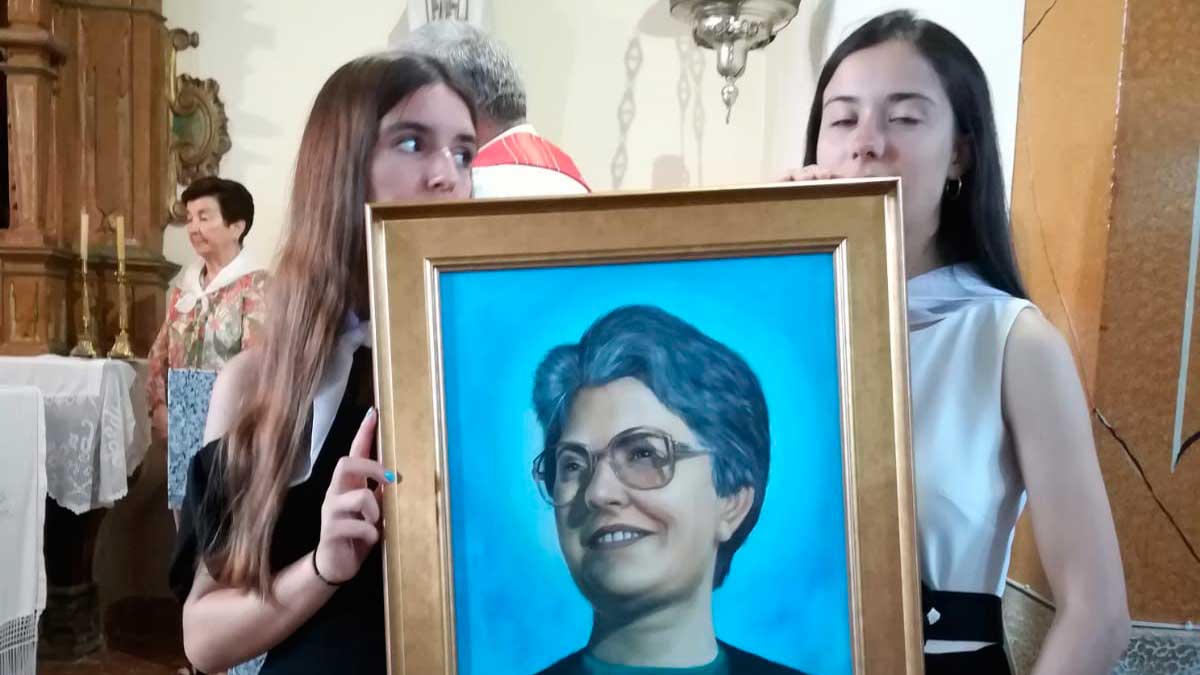 Dos jóvenes familares de Esther Paniagua muestran un retrato de la mártir.