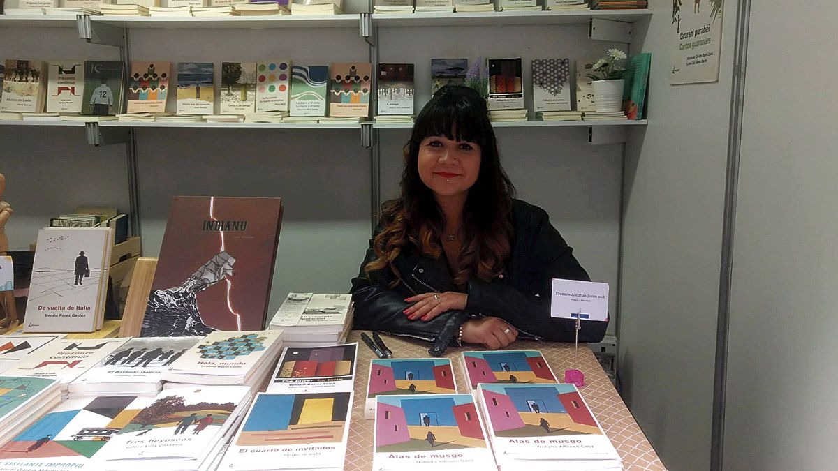 La escritora en la presentación de los Premios Jóvenes de Asturias y en un stand de la feria del libro. | L.N.C.