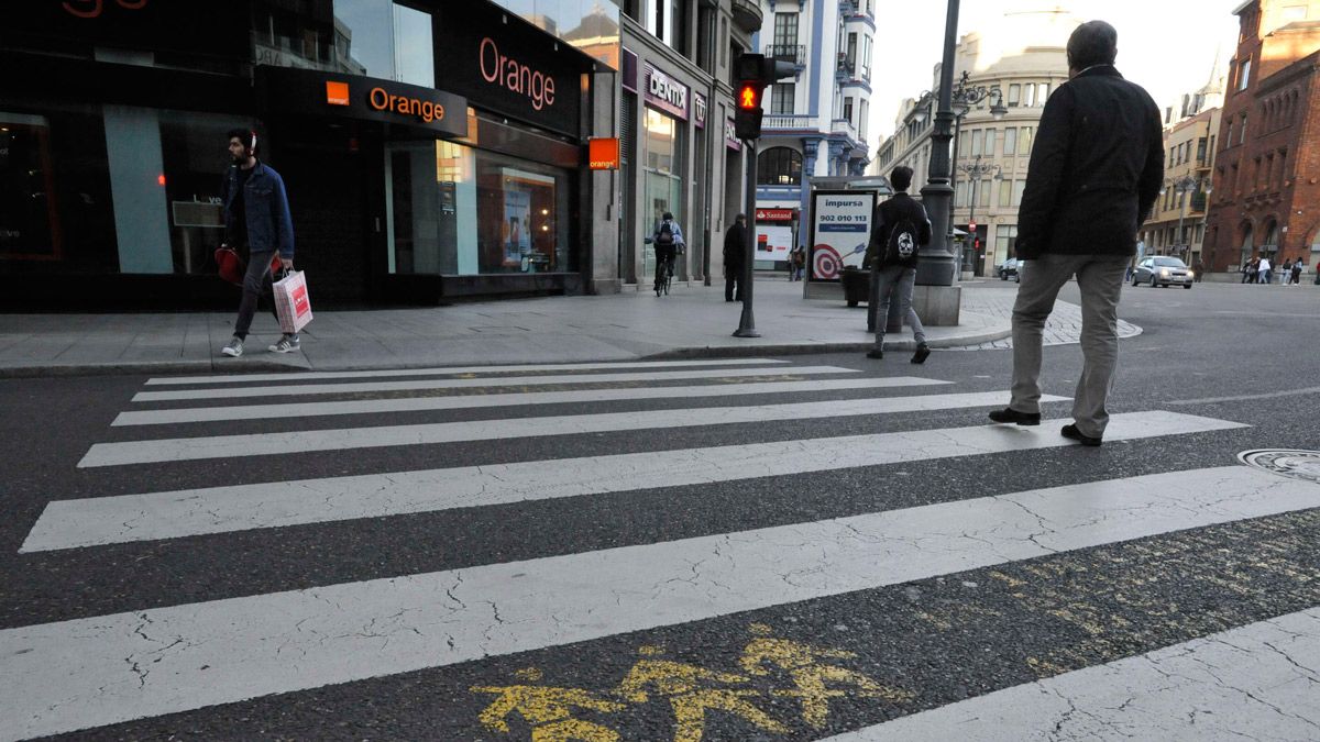 Dos peatones cruzan en rojo por el paso ubicado en la confluencia de la plaza de Santo Domingo con Gran vía de San Marcos. | DANIEL MARTÍN