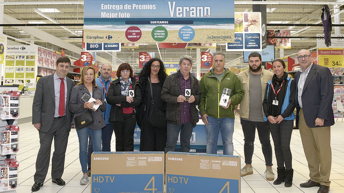 Foto de familia de los organizadores y ganadores del concurso ‘Tu foto del verano’ tras la entrega de premios este jueves en Carrefour. | MAURICIO PEÑA