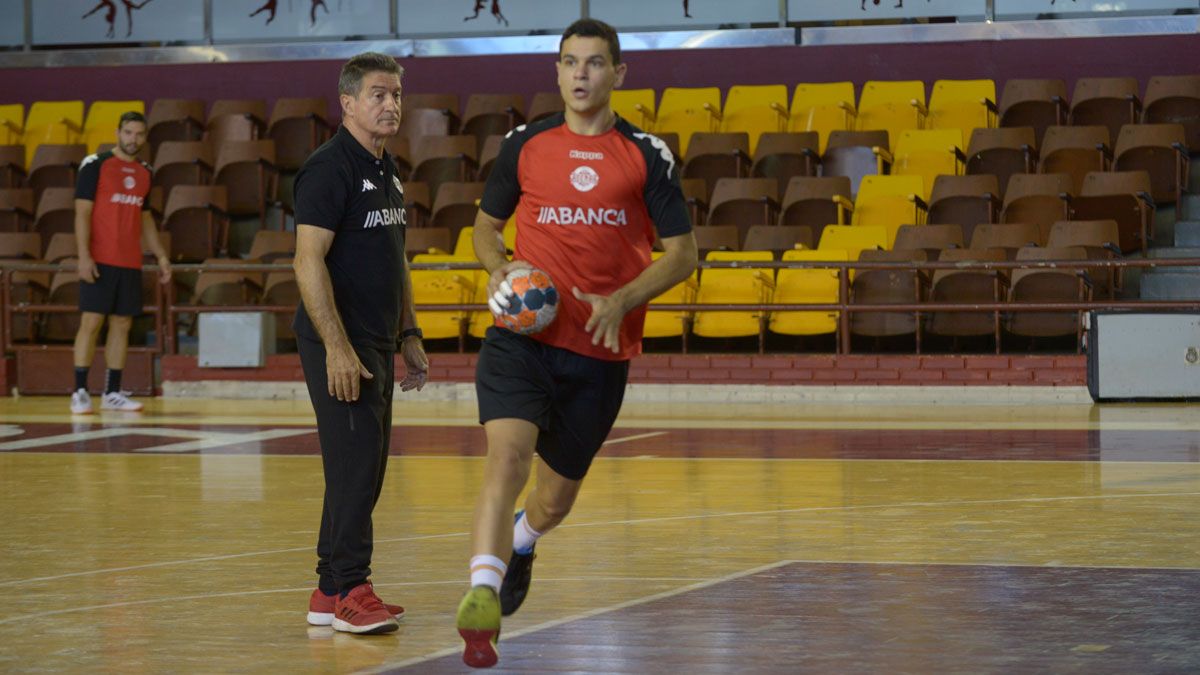 Álex Lodos da un pase ante la mirada de Cadenas durante un entrenamiento con el Ademar. | MAURICIO PEÑA