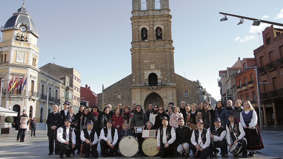 Fotografía de grupo de los miembros de Bañezaina, de la Coral del Milenario y antiguos coralistas tras la entrega del galardón. | ABAJO