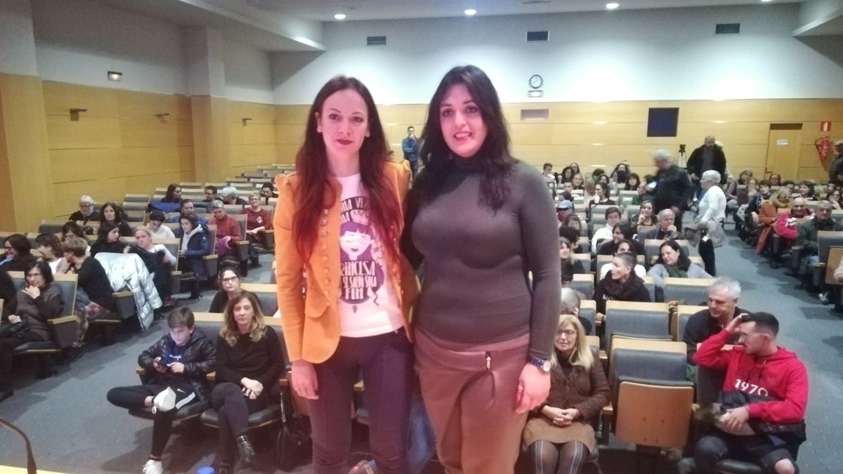 La concejala Lorena González y la activista Amelia Tiganus, ante un salón de actos con mucha asistencia. | D.M.