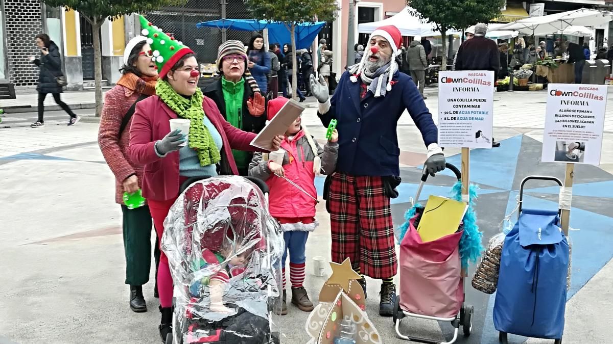 Los activistas pusieron en marcha este sábado en el mercado su performance de concienciación Clown Colillas. | D.M.