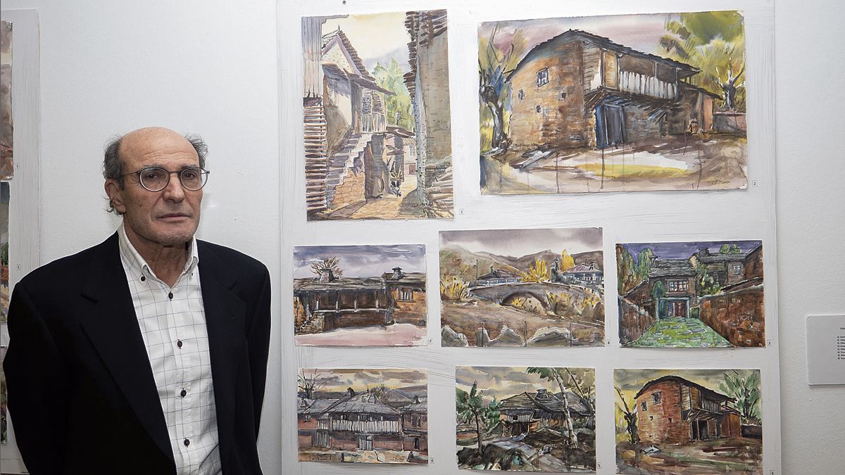 El artista José Antonio Barrera ante un panel de construcciones rurales leonesas. | VICENTE GARCÍA