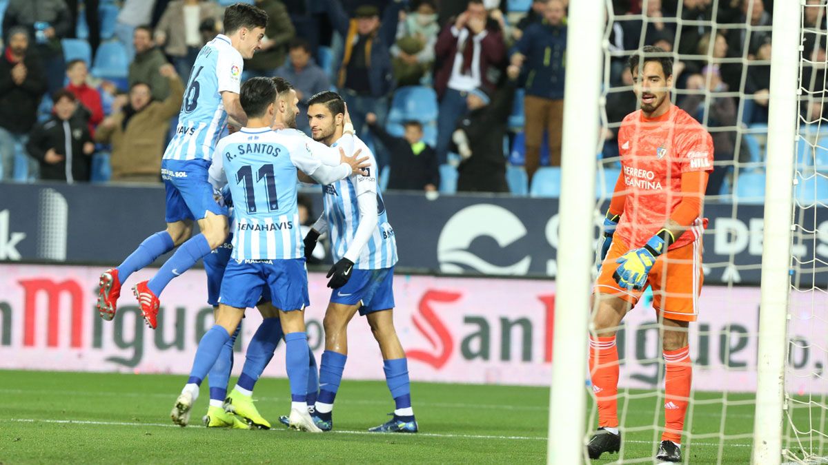 Gazzaniga se lamenta mientras los jugadores del Málaga celebran el gol. | SALVADOR SALAS/SUR