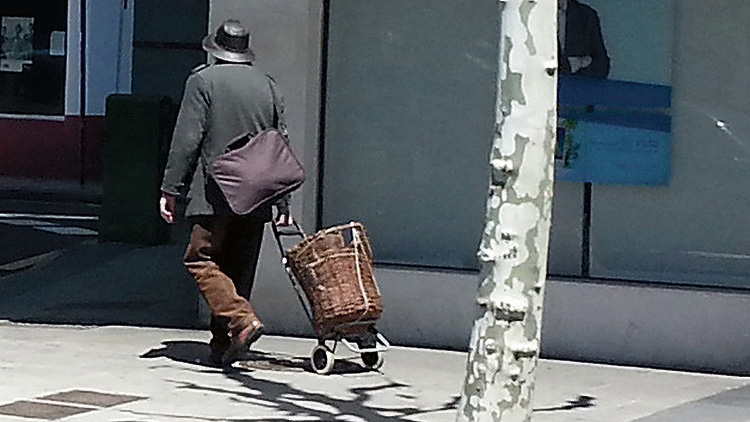 Pedro por León con una singular cesta de la compra, una cesta de vendimia.