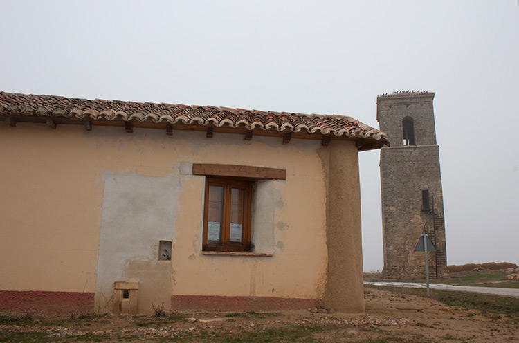 Escuelas de Santa María de los Oteros reconvertidas en iglesia y al fondo la torre del desaparecido templo. | T.G.