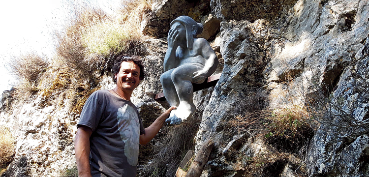 El escultor Amancio González junto a su obra, en la montaña gordonesa.