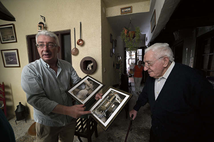 Jesús Antonio y su padre, Jesús Martínez, mirando alguna de las viejas fotografías que conservan en casa de su antiguo molino de linaza de arder. | MAURICIO PEÑA