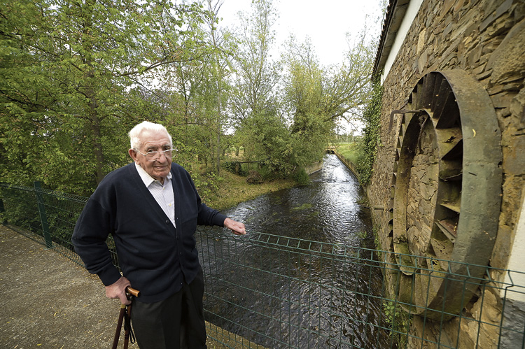 La presa de los Tres Concejos camina al lado del molino. Jesús sobre el puente de la presa y una espectacular pieza del molino en la pared. | MAURICIO PEÑA