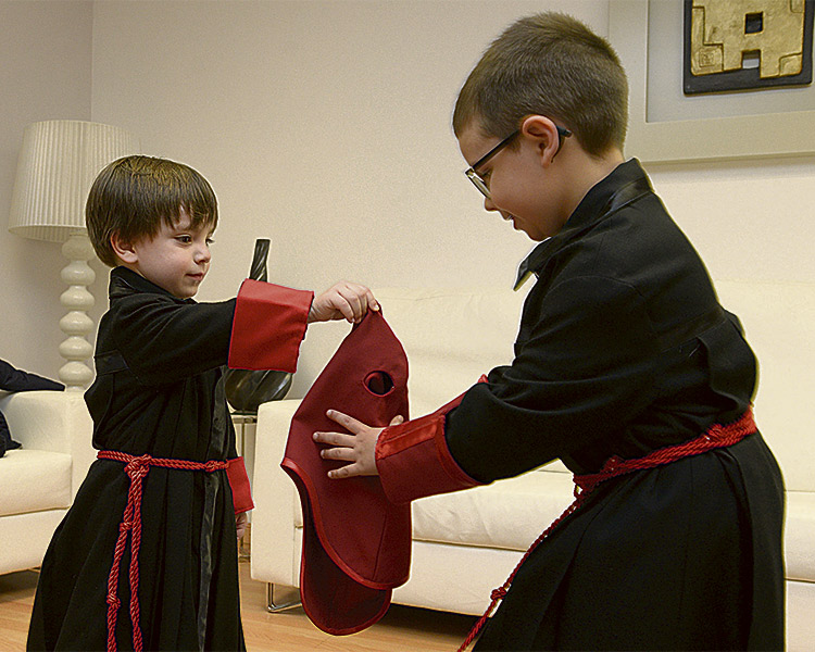 Rodrigo y Mateo, de tres y cinco años, ya tienen sus túnicas y capillos a punto para procesionar junto a su padre y su tío esta Semana Santa. | MAURICIO PEÑA